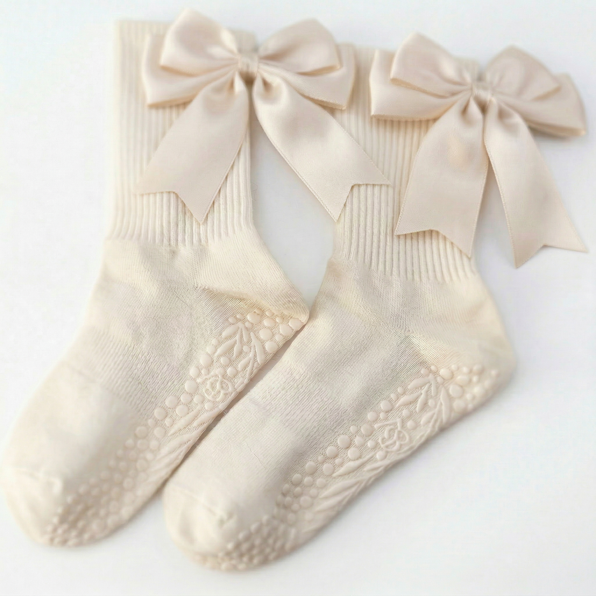 Light beige minimalist grip socks with bows by Bellona Velvet, showcasing the breathable organic cotton fabric and non-slip dual grip elements.