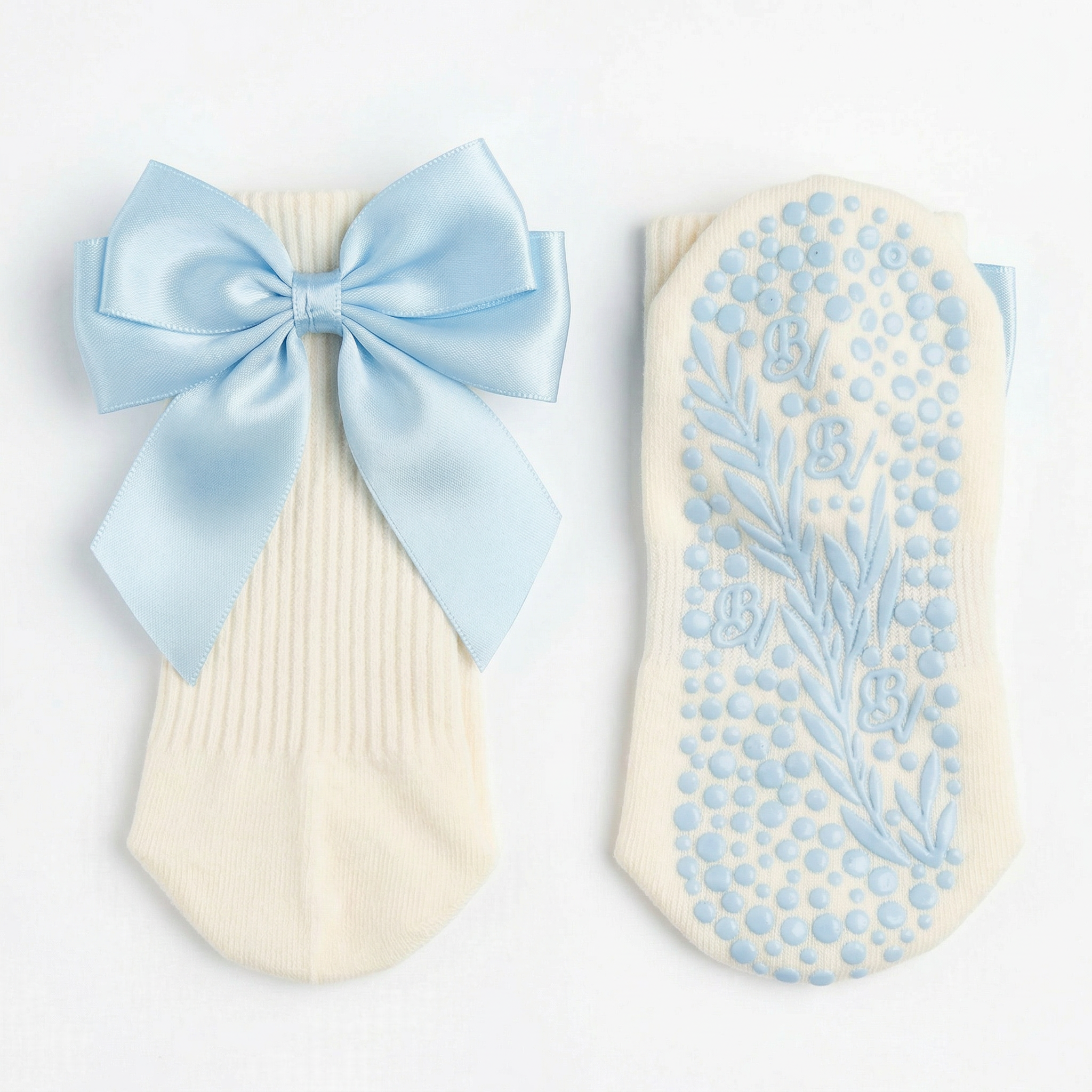 Baby blue GOTS-certified organic cotton grip socks with a delicate minimalist bow, highlighting Bellona Velvet's high-traction dual grip texture on the sole.