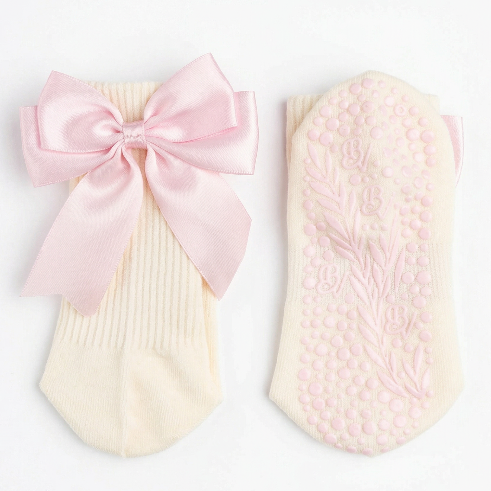 The Signature Ribbon Pilates Socks – Organic Cotton - Rosehip Blush: a cream pair featuring a vintage-style satin bow on the front and pink floral and dot non-slip grips on the sole.